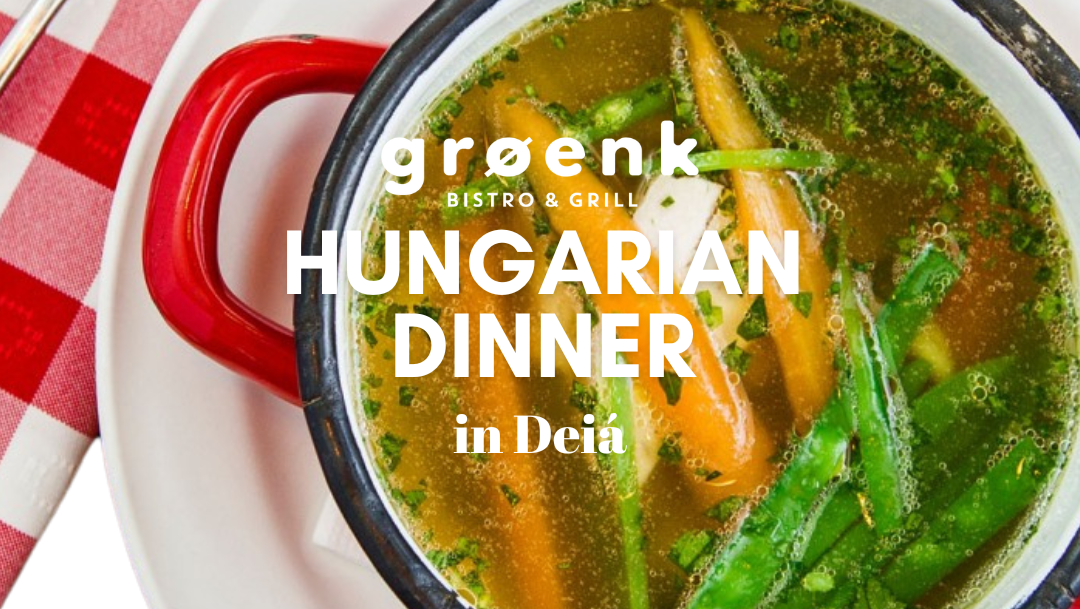 Close-up of a pot filled with Hungarian-style vegetable chicken soup, with carrots, green beans and fresh herbs.