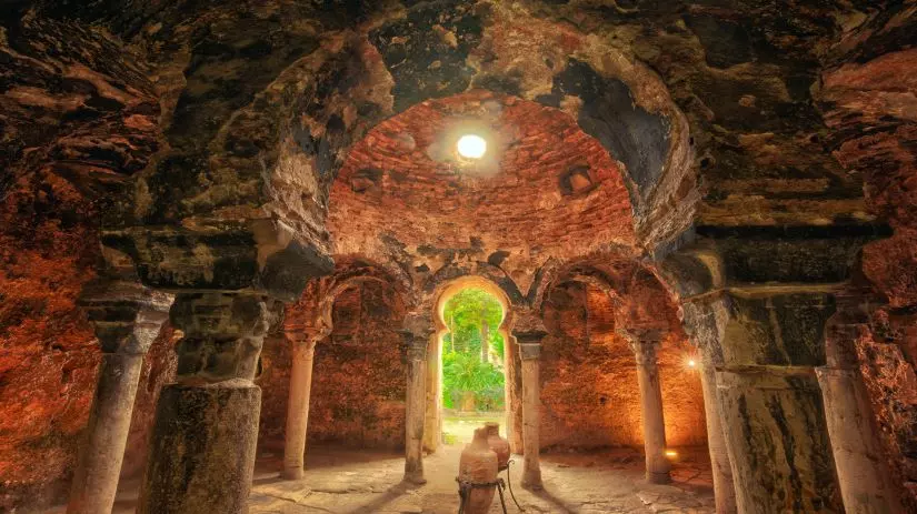 Interior of the Arab Baths in Palma with stone columns and a domed ceiling.