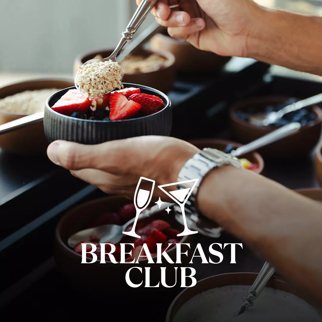 Bowl with strawberries and oats being prepared at a breakfast buffet.
