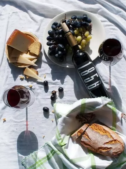 Wine bottle, bread, cheese and grapes prepared for a tasting at Bodega Macià Batle