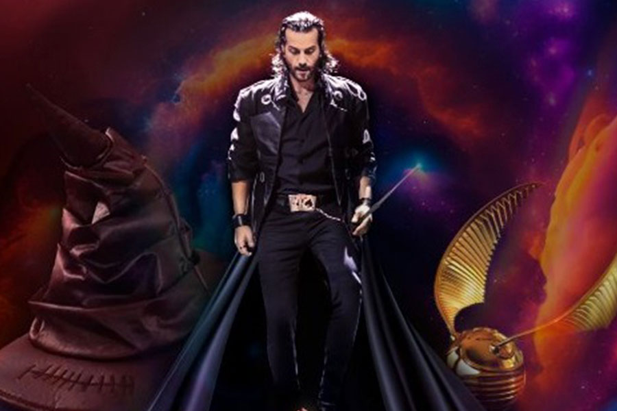 Performer dressed in black on stage during the magic show “De Muggle a Mago”.