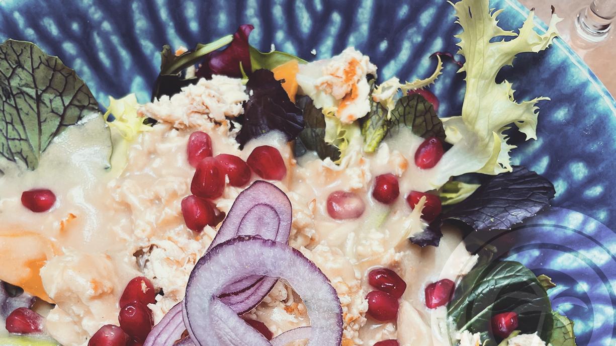 Chicken salad with mango, mixed leaves, red onion, avocado and pomegranate seeds topped with honey and mustard vinaigrette.