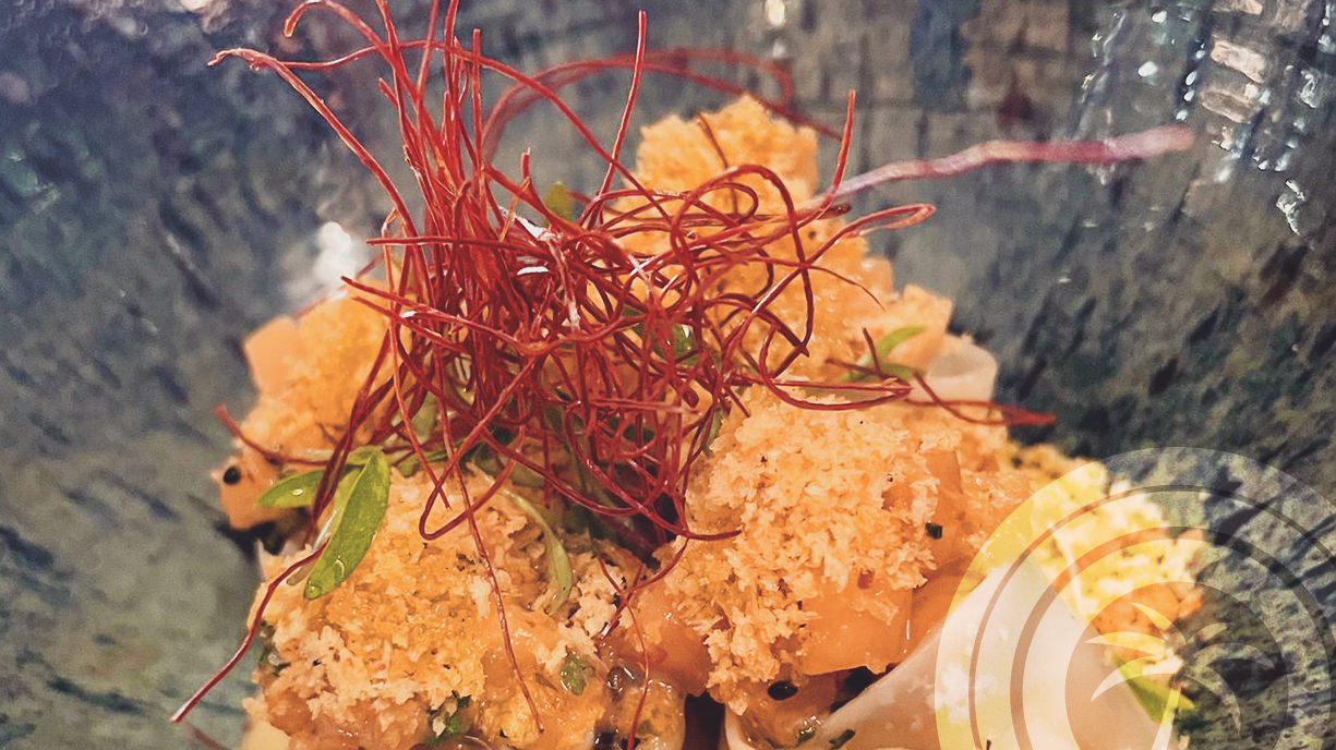 Crispy panko-coated prawns topped with red chili threads and green onions in a ceramic bowl at Arume restaurant, Palma.
