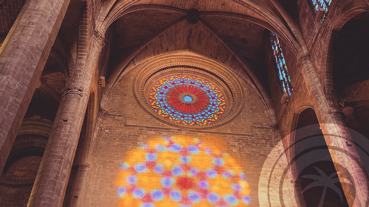 Coloured light from a rose window projected onto the interior wall of Palma Cathedral.