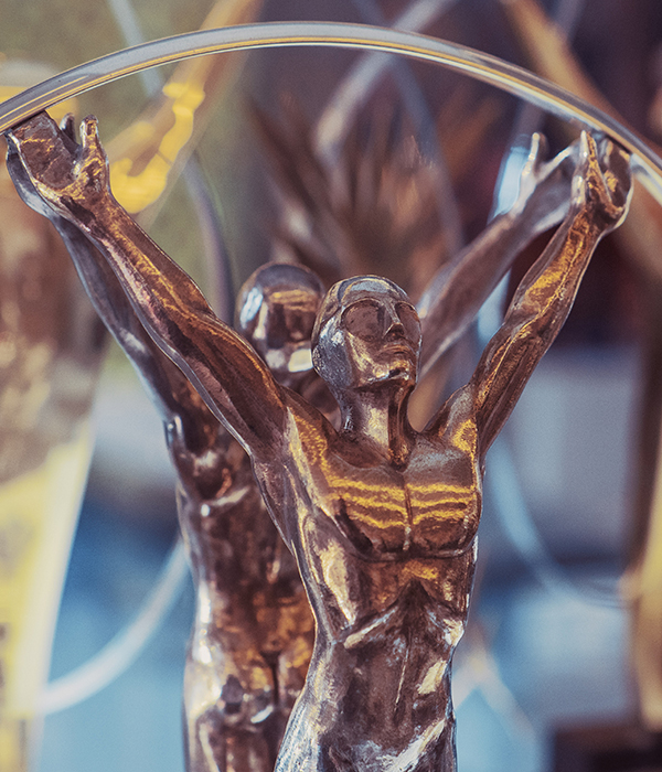 Close-up of a bronze trophy figure with raised arms displayed at the Rafa Nadal Museum.