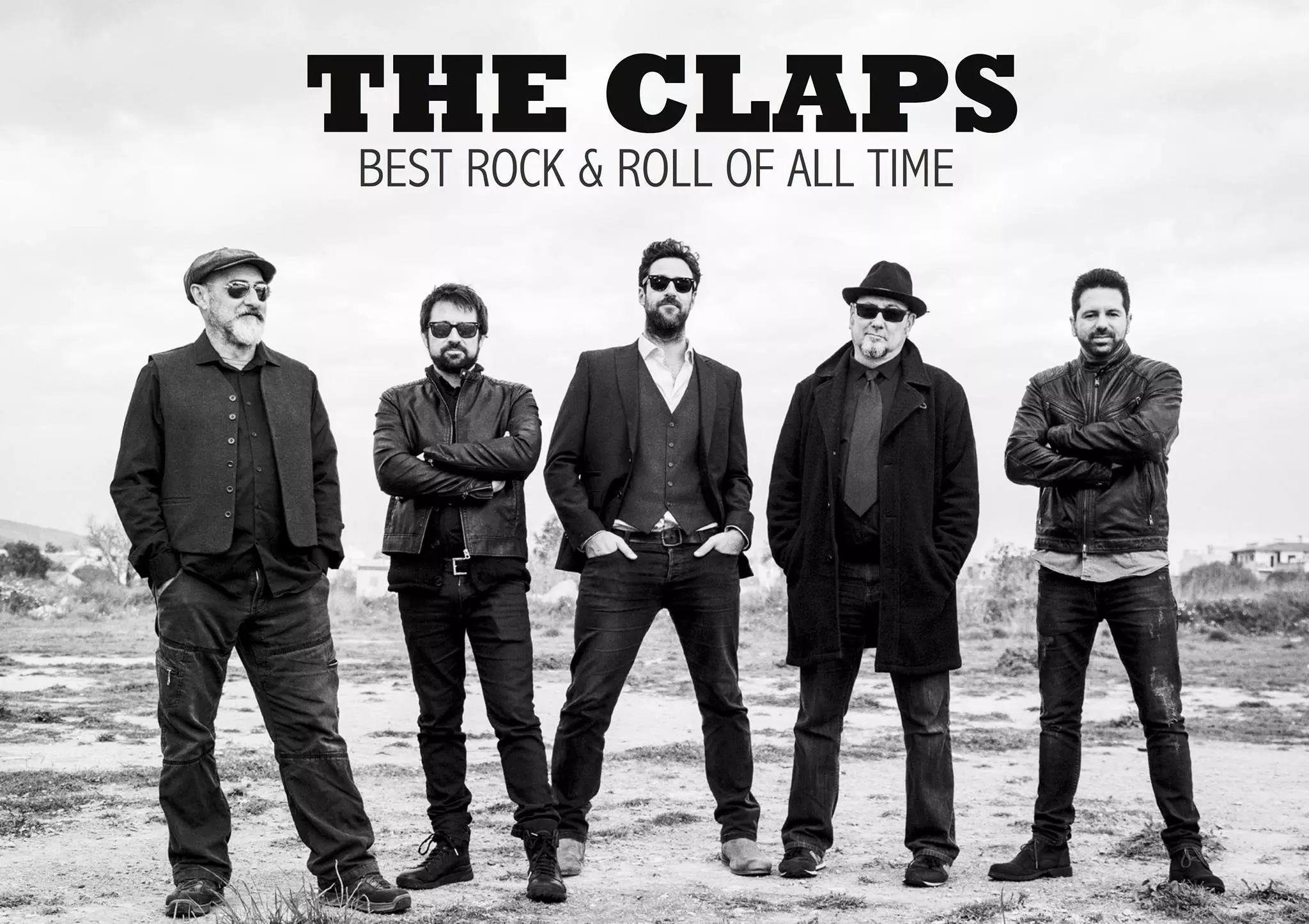 Black-and-white photo of the rock band The Claps standing outdoors, dressed in dark clothing and sunglasses.